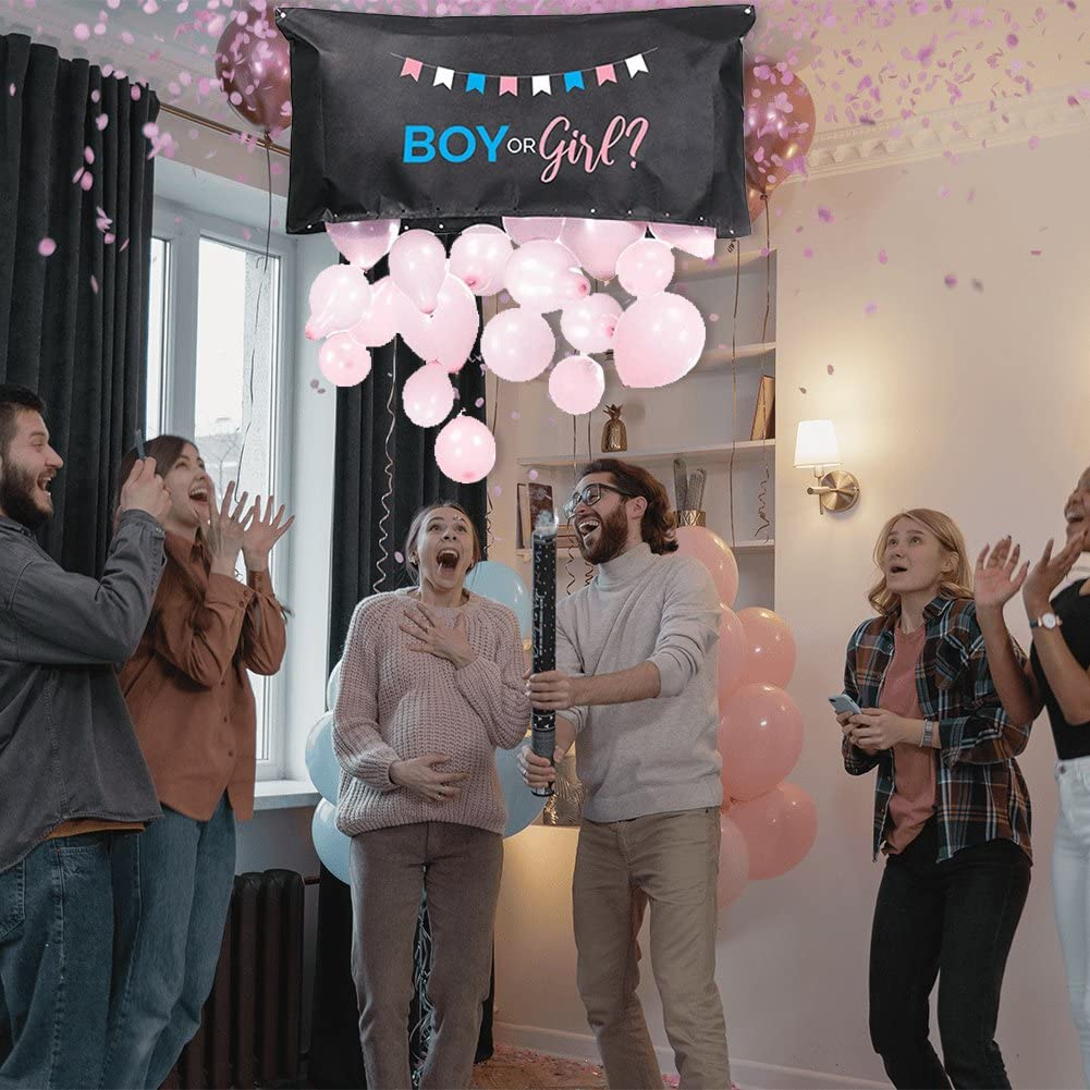 Group of friends celebrating with a Boy or Girl? gender reveal balloon drop bag releasing pink balloons.