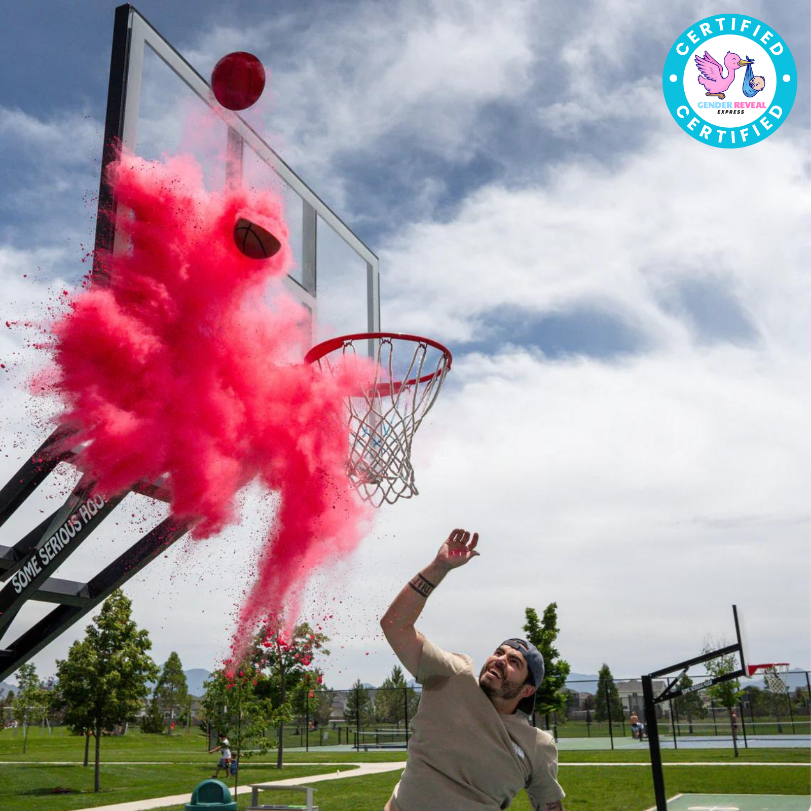 Man scoring with Gender Reveal Basketball releasing pink powder explosion at a basketball hoop