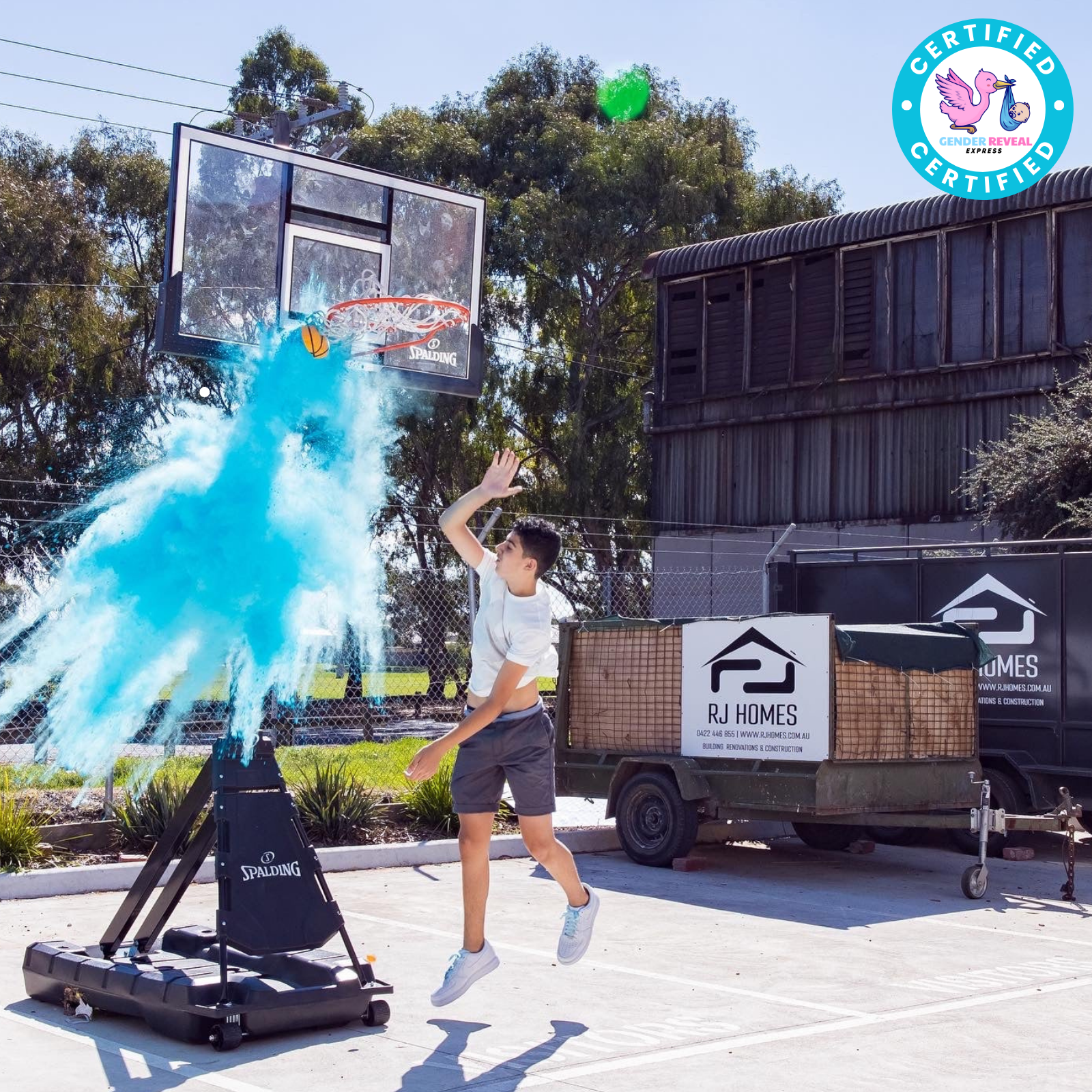 Boy scoring with Gender Reveal Basketball releasing blue powder explosion at a hoop