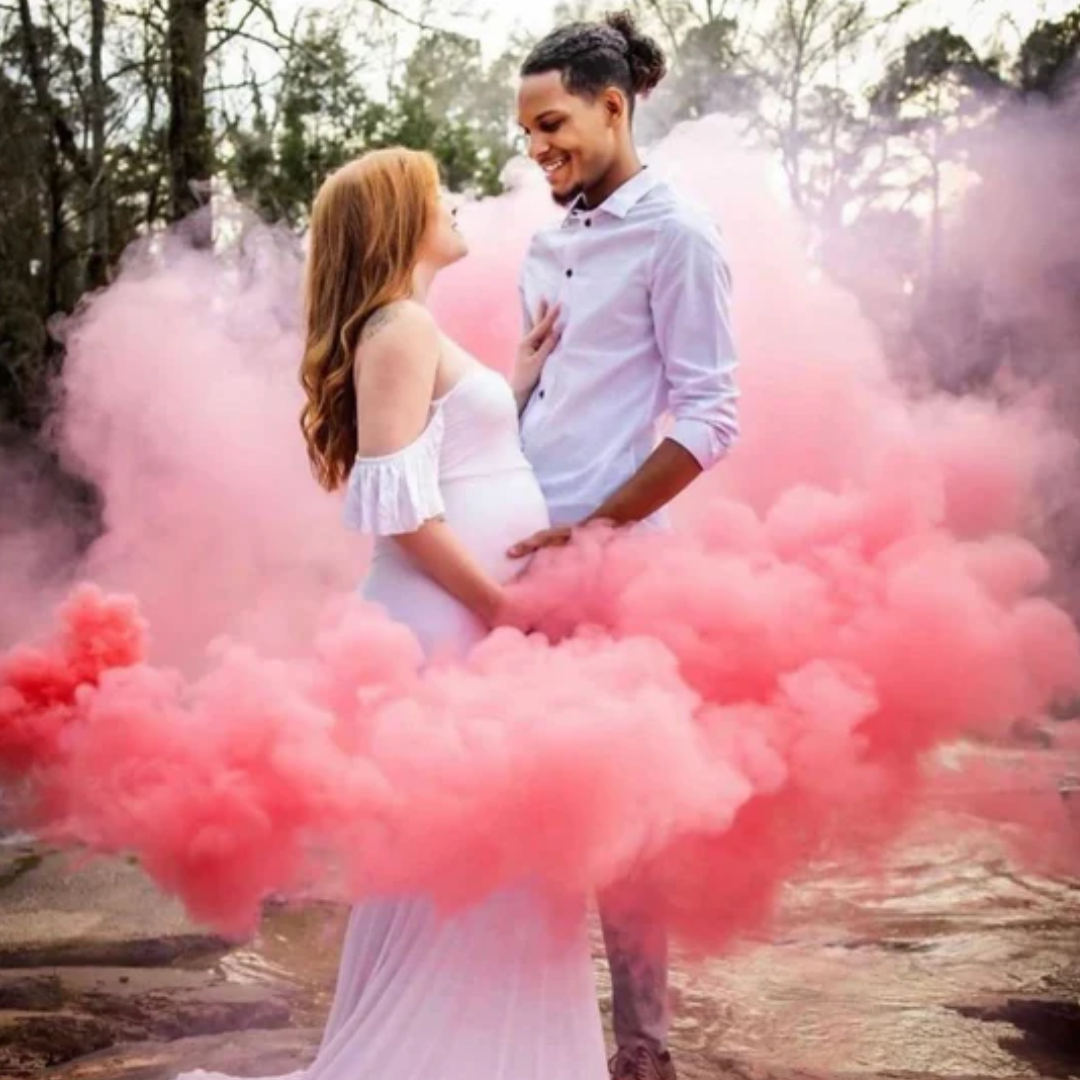 Couple standing in a pink smoke cloud during a gender reveal celebration