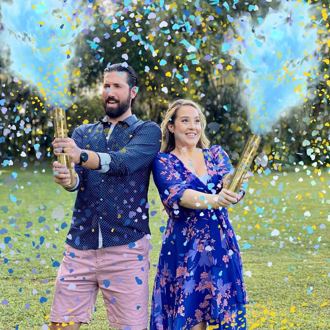 Couple using Luxury Gender Reveal Cannon with blue confetti and powder burst outdoors