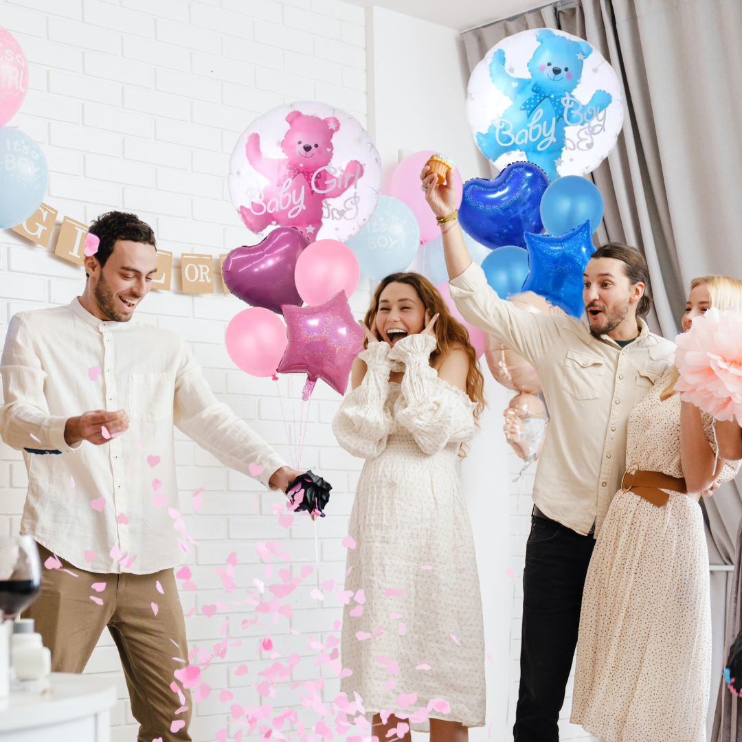 Group celebrating gender reveal with pink confetti and blue and pink teddy bear balloons