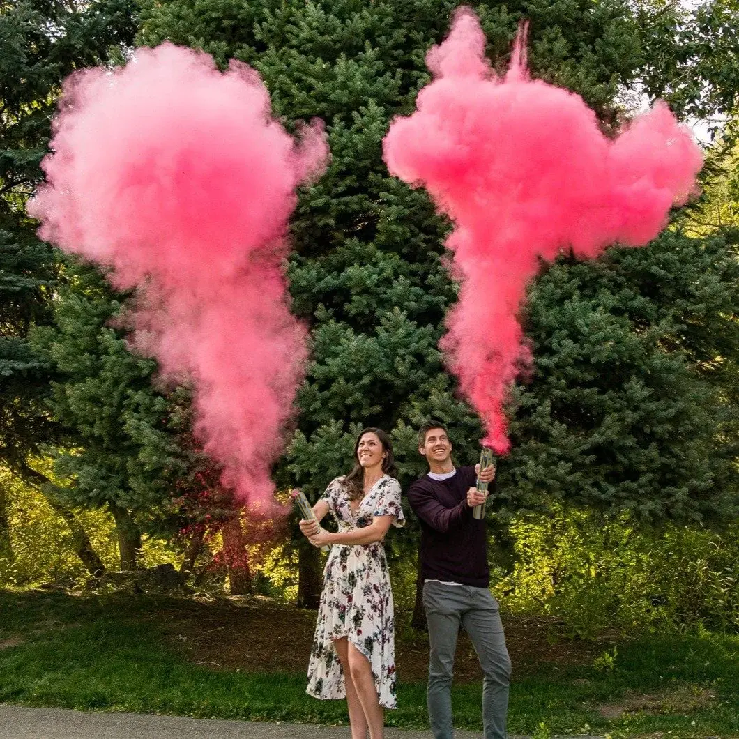 Couple using Luxury Gender Reveal Cannon with pink powder burst outdoors