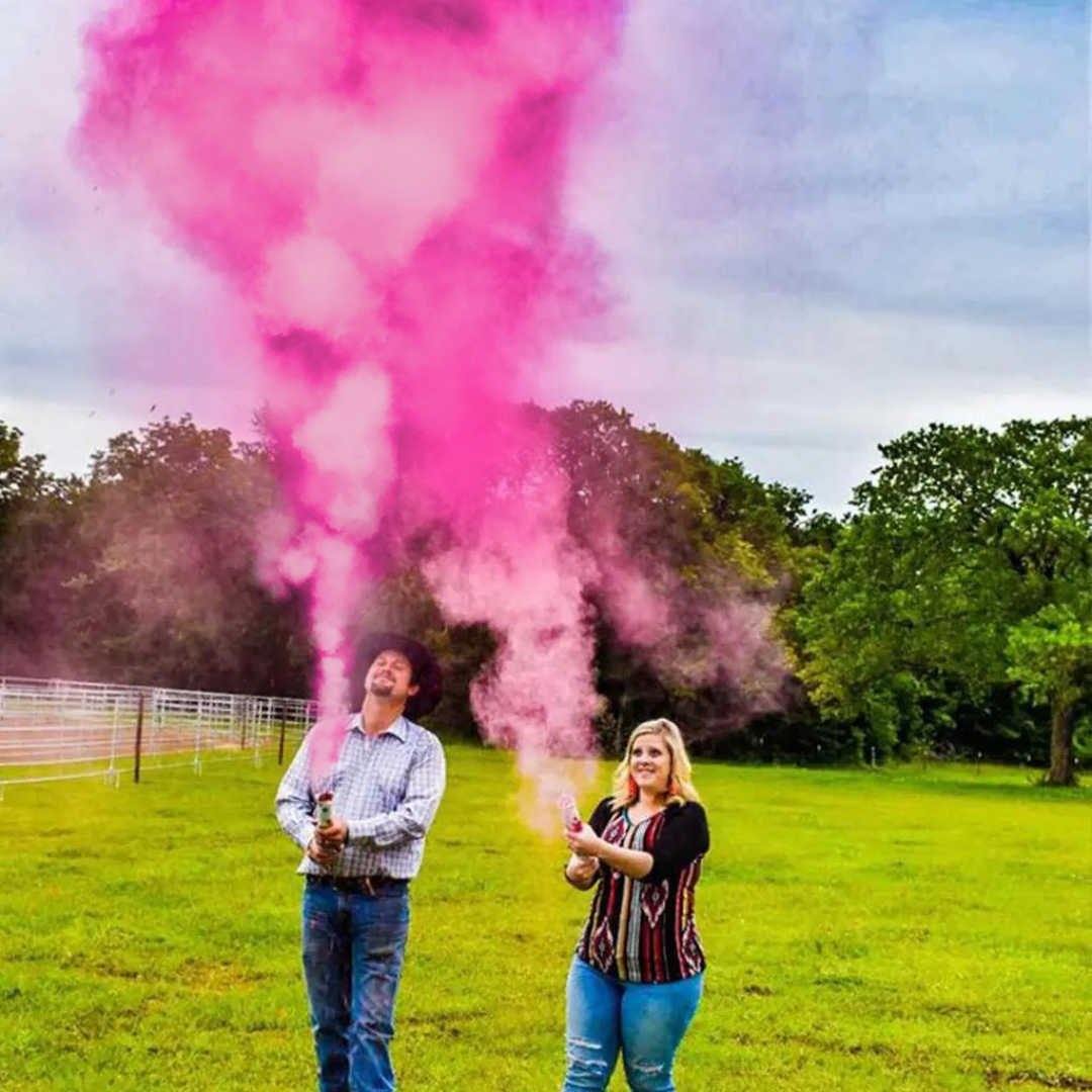 Family using Gender Reveal Powder Cannon with Pink smoke in a park